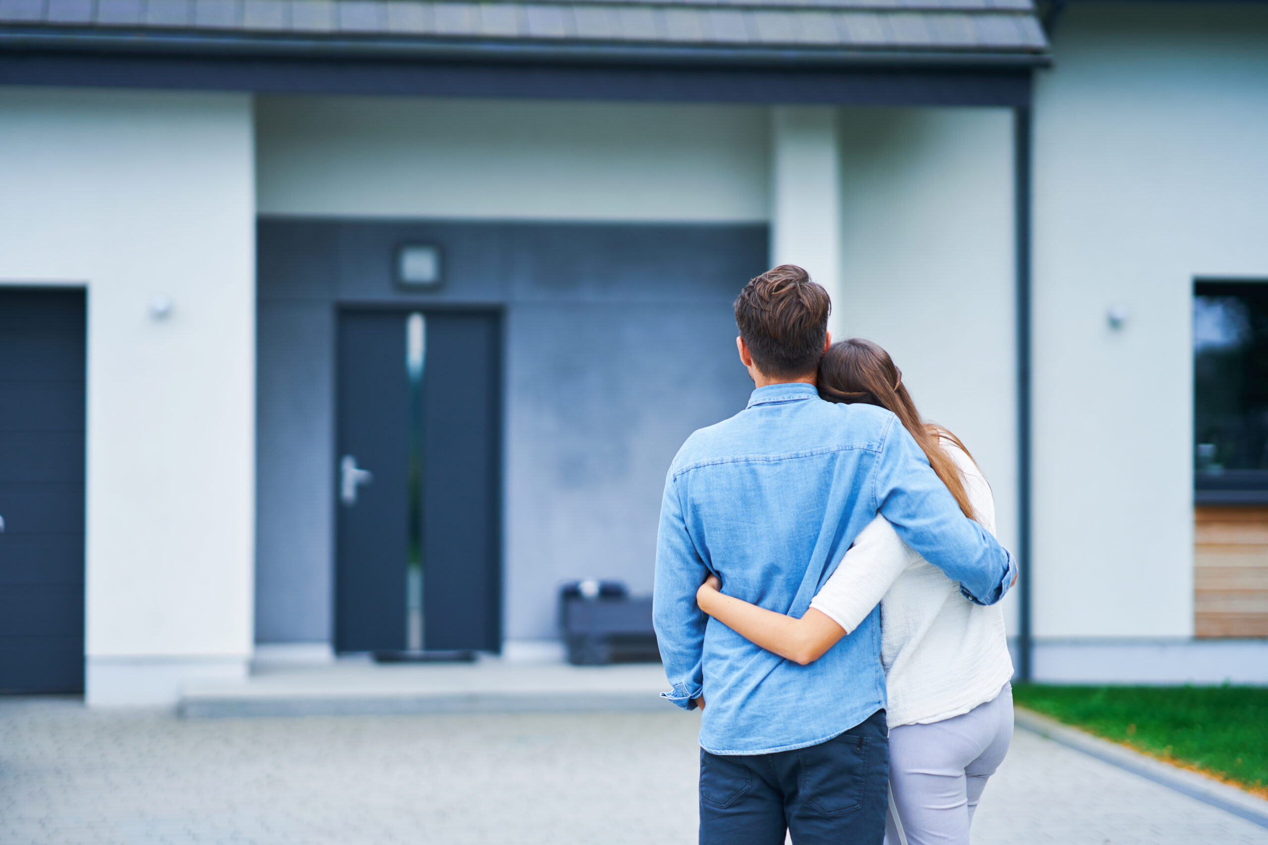 Picture of couple in front of one-family house in modern residential area