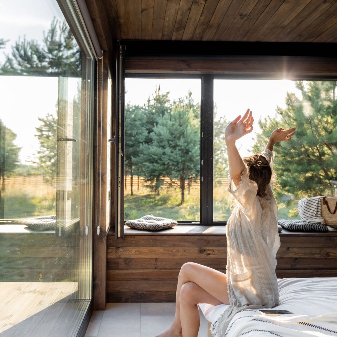 aufstehen_fensterfront_bett_frau aufstehen_fensterfront_bett_frau